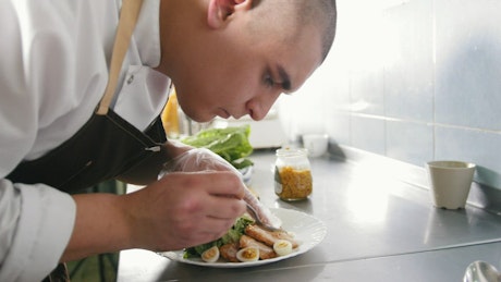 Chef carefully preparing a dish.