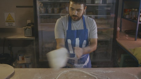 Chef doing acrobatics with the dough of a pizza