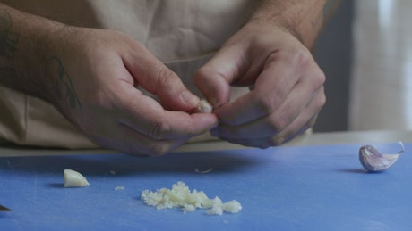 Chef peeling garlic.
