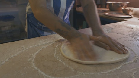 Chef shaping a pizza.