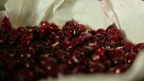 Cherries being sprinkled with sugar.