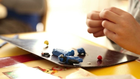 Child creating figurines with Play Doh.