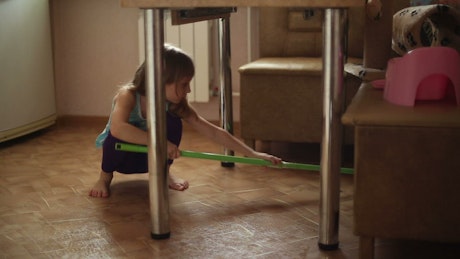 Child helps to do the housework by mopping.