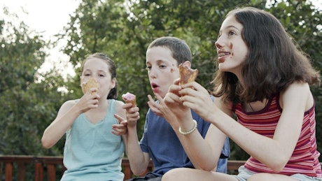 Children having a fun time while eating ice cream.