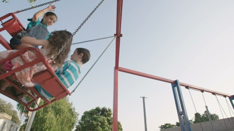 Children on a familiar swing at a public playground.
