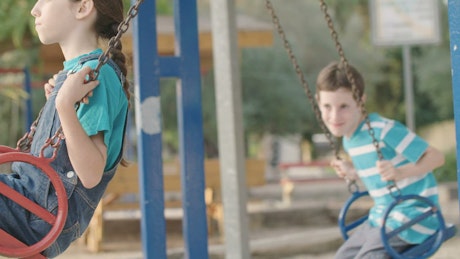Children on swings at a public playground.