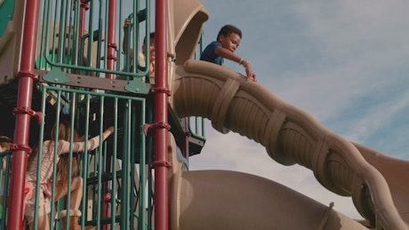Children sliding down a slide.
