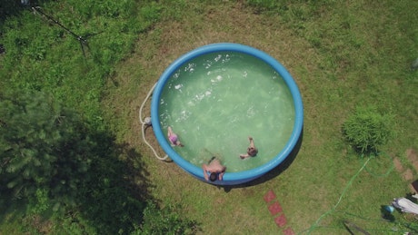 Children splashing in a backyard pool
