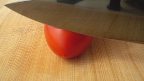 Chopping a tomato.