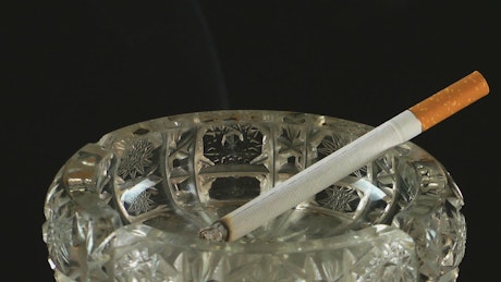 Cigarette burning in an ashtray.