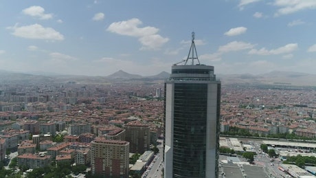 City around a skyscraper in an aerial shot.