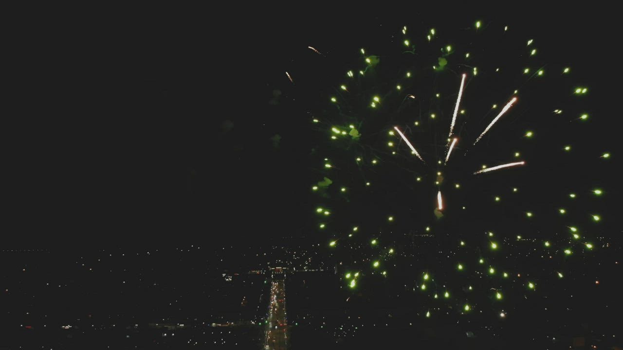 City lig LIVE DRAW hts shining below a big fireworks display