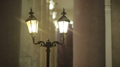 Classic street lights while it's snowing.