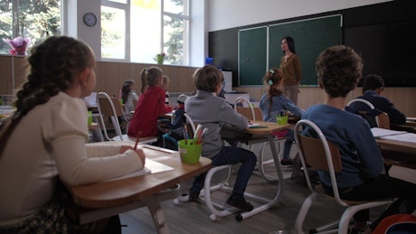 Classroom with children raising their hands.