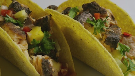 Close shot of a couple of tacos on a plate.