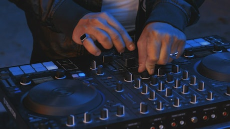 Close shot of a DJ playing at night