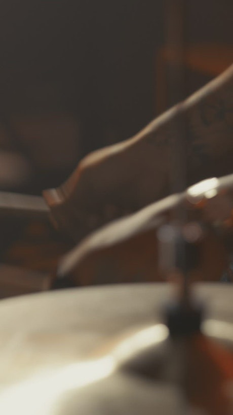 Close shot of a drum kit while a drummer plays