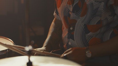 Close shot of a drummer playing in a studio.