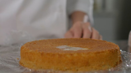 Close shot of a pastry chef preparing a cake.