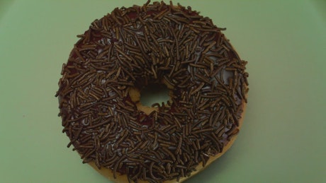 Close shot of a rotating chocolate donut.