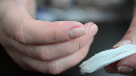 Close shot of a woman's hands cleaning her nails.