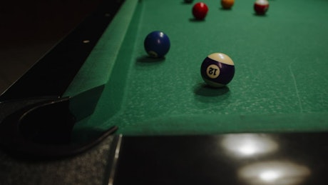 Close up of a billiards table being played.