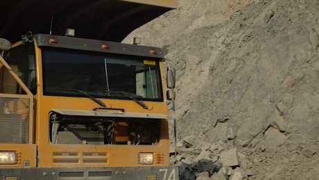 Close up of a large mining truck driving through a quarry site.