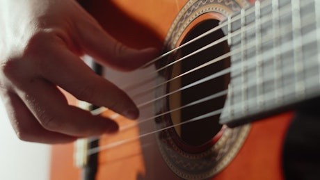 Close up of a musician expertly strumming the strings of a guitar.