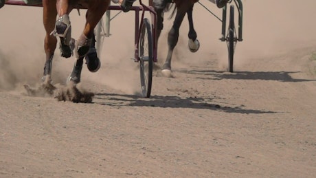 Close up of a race with horses and wagons.