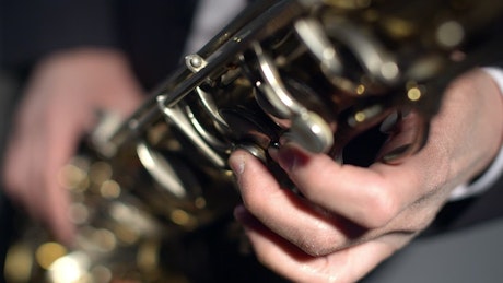 Close up of a saxophone being played.