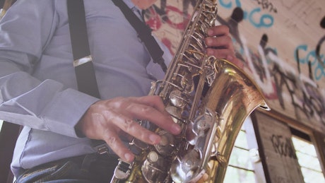 Close up of a saxophonist in an abandoned spot.
