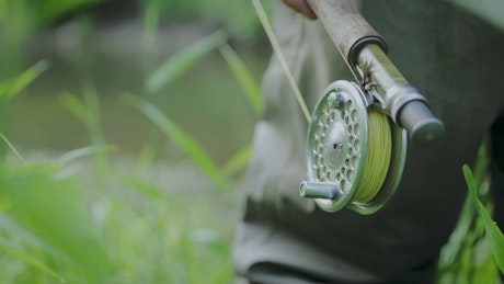 Close up of an angler's fishing rod and reel.