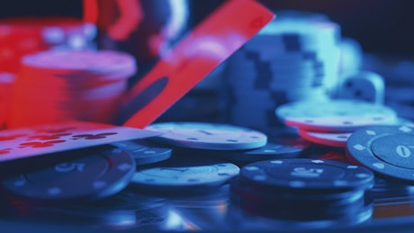 Close up of casino chips with neon lights.