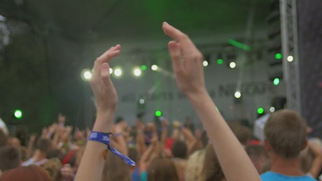 Close up of girl's hands clapping at a music show.