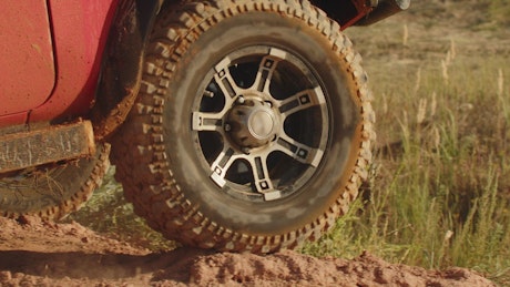 Close up of large SUV tyres driving off road.