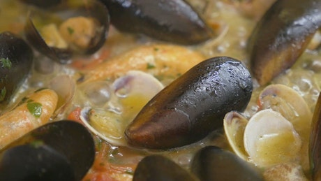 Close up of seafood bubbling away in a pan.