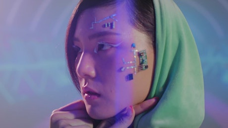 Close up on young woman with circuits on her face.