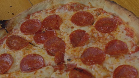 Close up shot of a pepperoni pizza on a table.