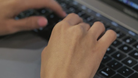 Close up shot of a person typing on a laptop.
