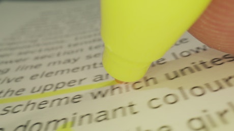 Close up shot of a text marker underlining in a book