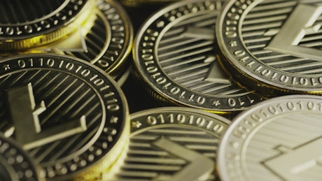Close-up shot of lite coins rotating.