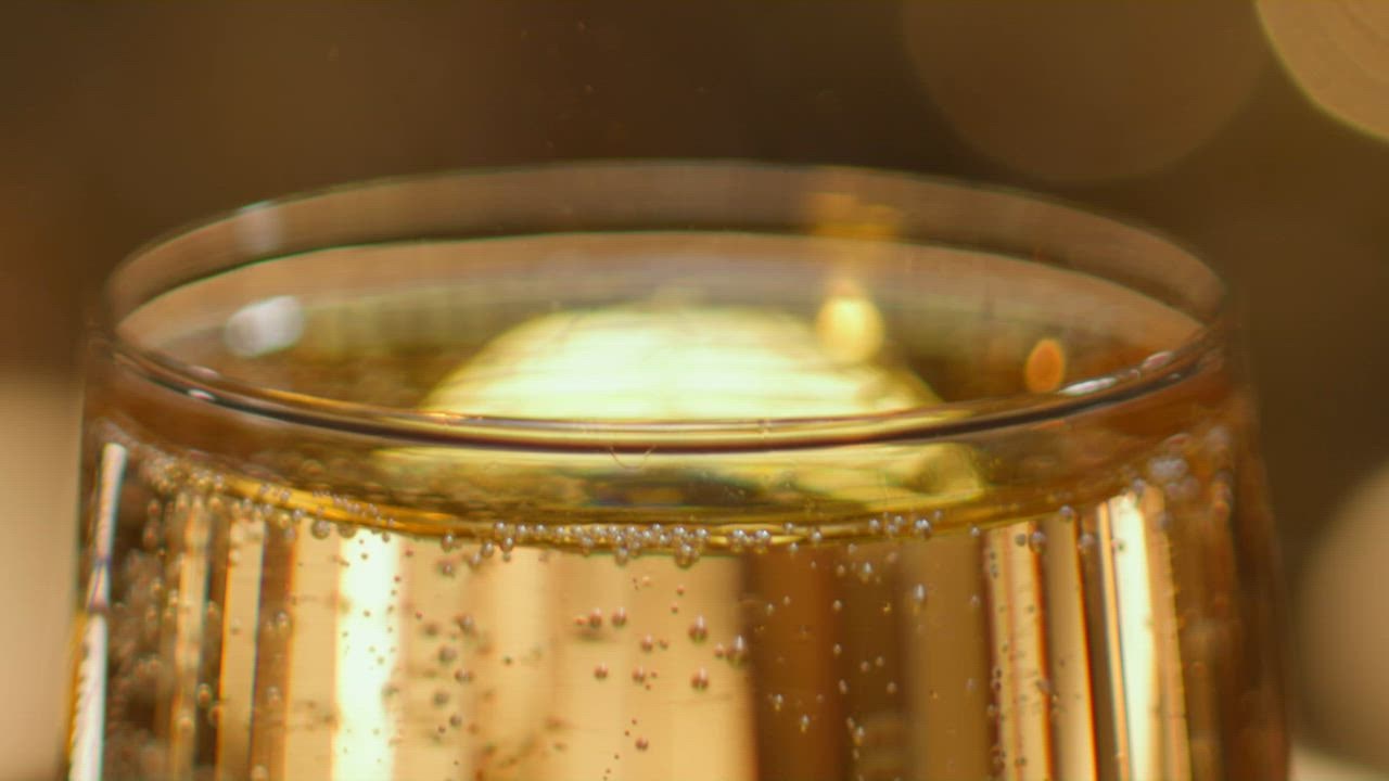 ⁣Tembakan close up tepi gelas yang diisi dengan minuman berkilau keem 888slot asan