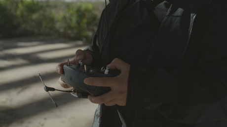 Close up view of a man controlling a drone outdoors.