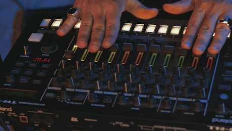 Close-up view of the hands of a DJ using a console.