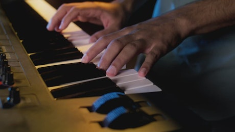 Close view of a keyboard player's hands playing.