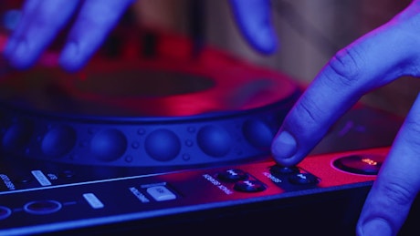 Closeup of a DJ mixing music on a turntable.