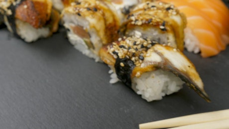 Closeup of sushi rolls on black background.