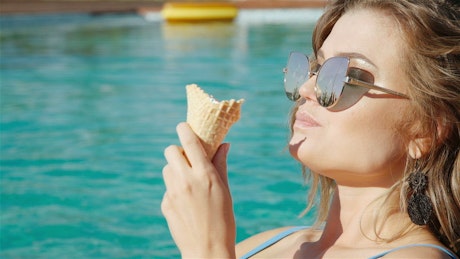 Closeup of woman eating ice cream in swimsuit.