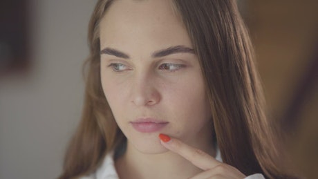 Closeup of young woman thinking about decision
