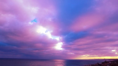 Clouds colored in pink and violet in the sunset.